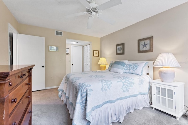 bedroom with ceiling fan, a closet, and light colored carpet