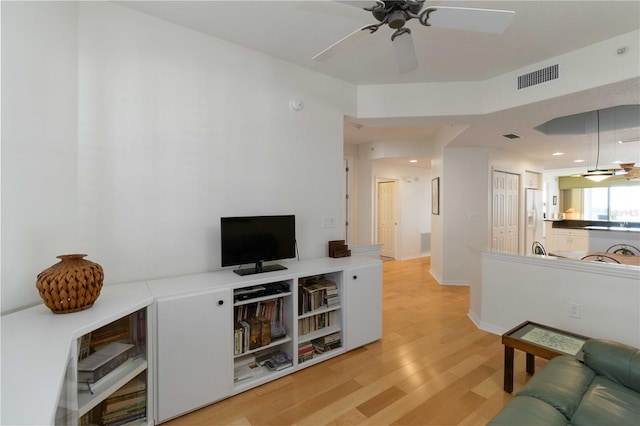 living room featuring light hardwood / wood-style flooring and ceiling fan