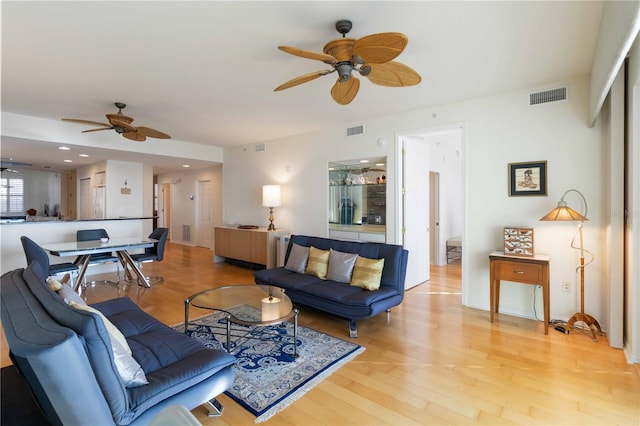 living room featuring light hardwood / wood-style floors and ceiling fan