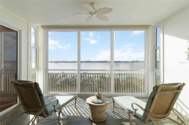 sunroom / solarium featuring a water view and ceiling fan