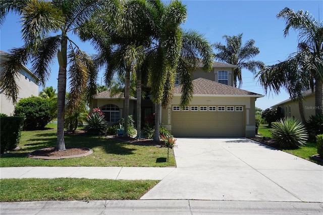 mediterranean / spanish-style house featuring a garage and a front lawn