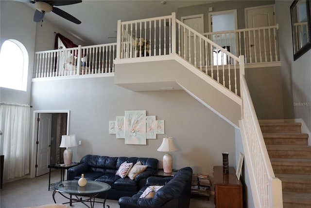 living room with carpet floors, ceiling fan, and a high ceiling