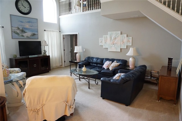 living room featuring light colored carpet and a towering ceiling