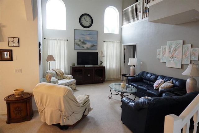 carpeted living room with a high ceiling