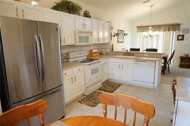 kitchen featuring white cabinetry, pendant lighting, vaulted ceiling, an inviting chandelier, and white appliances