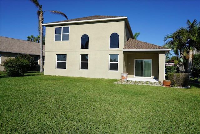 rear view of house featuring a lawn