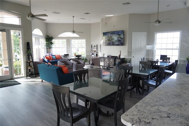 dining space featuring hardwood / wood-style flooring, ceiling fan, and a high ceiling