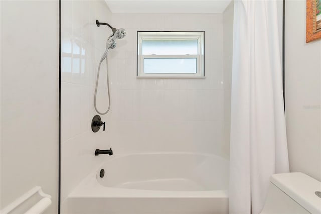 bathroom featuring shower / bath combo with shower curtain and toilet