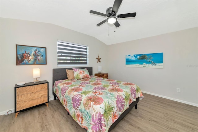 bedroom featuring ceiling fan, hardwood / wood-style floors, and lofted ceiling