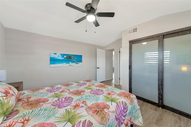 bedroom with light wood-type flooring, vaulted ceiling, and ceiling fan