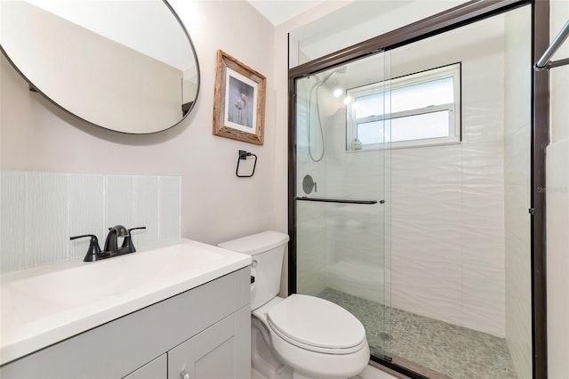 bathroom with vanity, toilet, and a shower with door