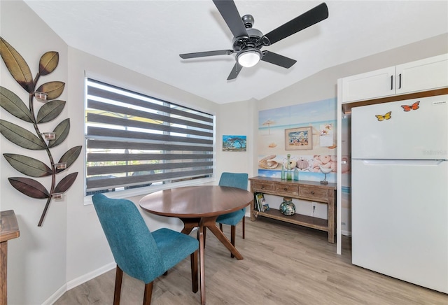 dining room featuring vaulted ceiling, light hardwood / wood-style flooring, and ceiling fan