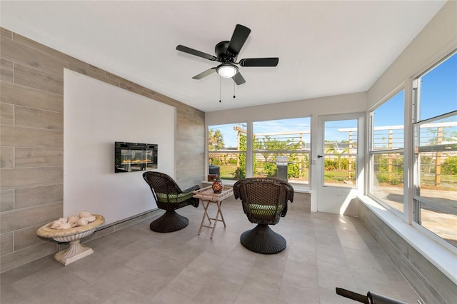 living area with ceiling fan and light tile patterned floors