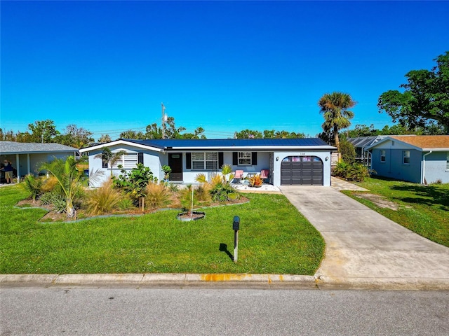 ranch-style house with a garage, a front yard, and solar panels