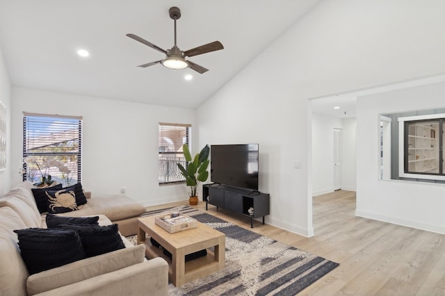 living room featuring ceiling fan, plenty of natural light, high vaulted ceiling, and light wood-type flooring