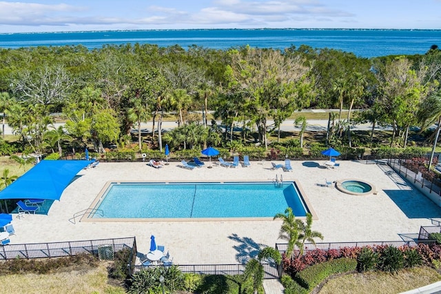 view of swimming pool with a water view and a patio area