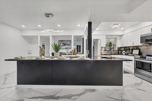 kitchen with white cabinets, backsplash, stainless steel appliances, and hanging light fixtures