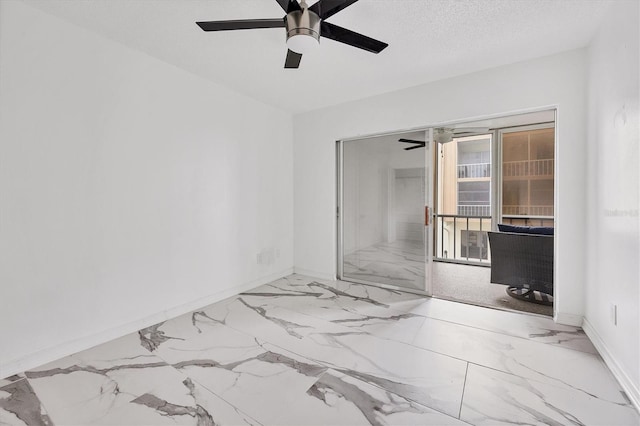 unfurnished room with ceiling fan and a textured ceiling