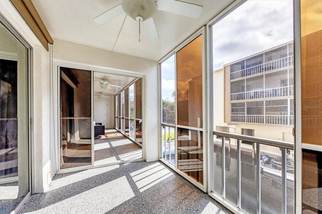 unfurnished sunroom with ceiling fan