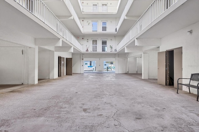 unfurnished living room with concrete flooring and a high ceiling