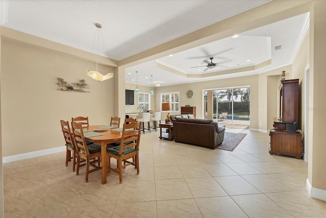 dining room featuring a raised ceiling, crown molding, ceiling fan, and light tile patterned floors