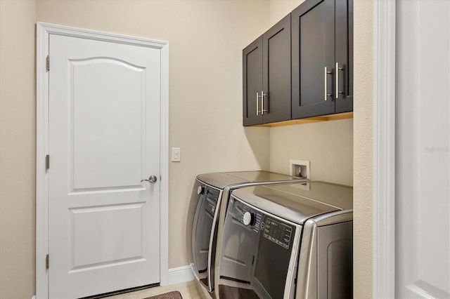 washroom with washer and clothes dryer and cabinets