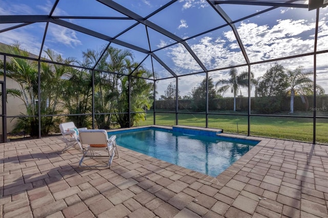 view of swimming pool with a lawn, a patio area, and a lanai