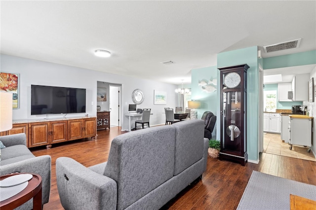 living room with dark hardwood / wood-style floors and a notable chandelier