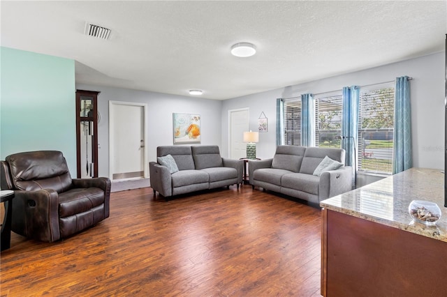 living room with dark hardwood / wood-style flooring and a textured ceiling