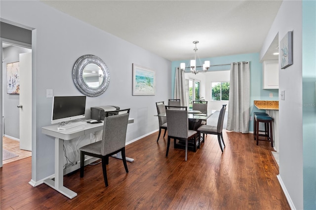 dining room with dark hardwood / wood-style floors and a notable chandelier