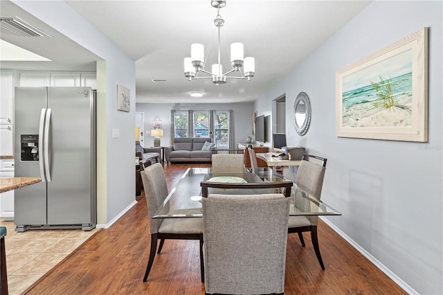 dining space featuring light hardwood / wood-style flooring and a notable chandelier