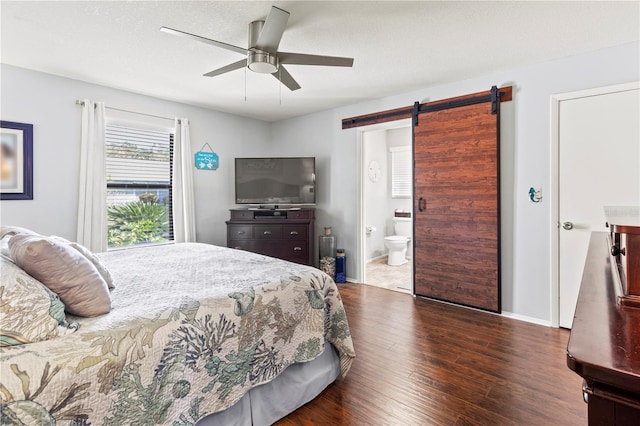 bedroom featuring connected bathroom, a barn door, ceiling fan, and dark wood-type flooring