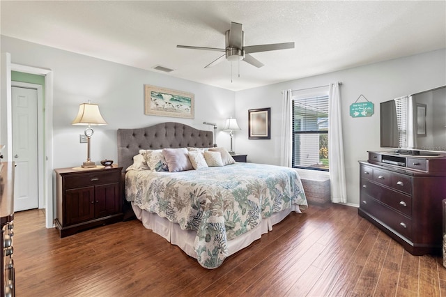 bedroom featuring a textured ceiling, ceiling fan, and dark wood-type flooring