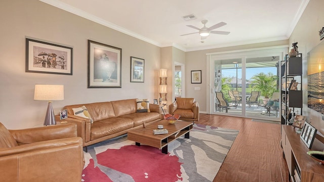 living room featuring ceiling fan, wood-type flooring, and crown molding