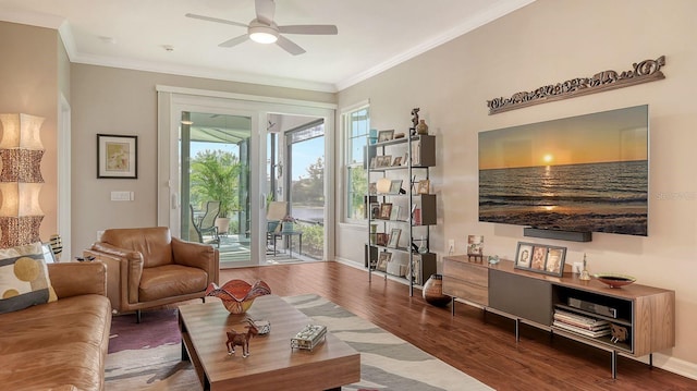 living room with hardwood / wood-style flooring, crown molding, and ceiling fan