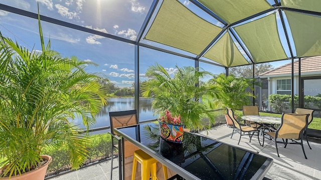 sunroom featuring a water view