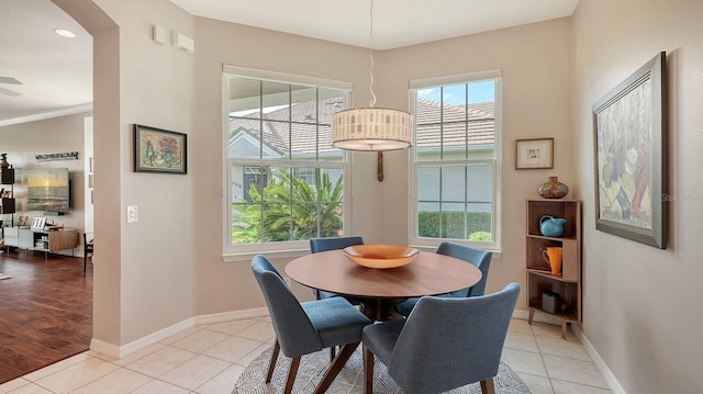 dining area with light wood-type flooring, ceiling fan, and crown molding