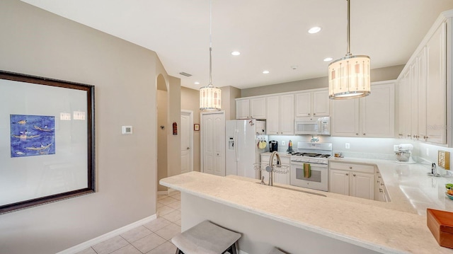 kitchen with pendant lighting, kitchen peninsula, white cabinetry, and white appliances