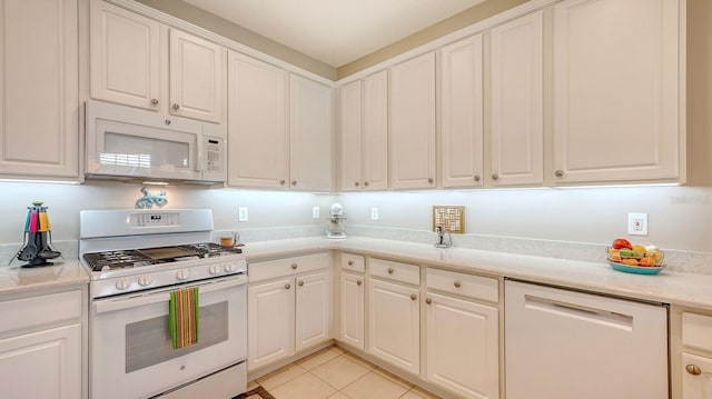 kitchen featuring white cabinetry, white appliances, and light tile patterned floors