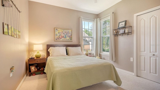 carpeted bedroom featuring ceiling fan and a closet