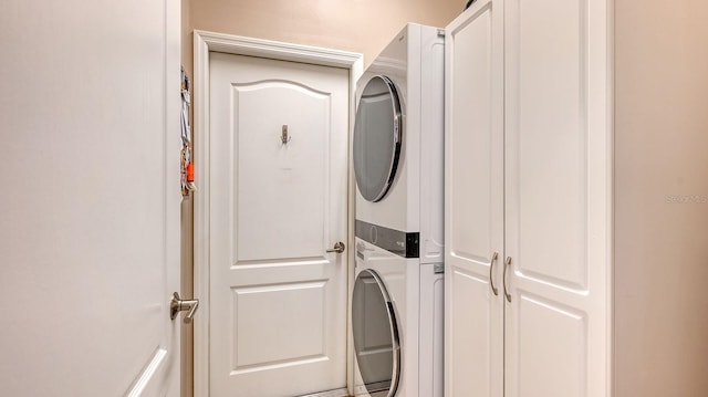 clothes washing area with stacked washer / dryer