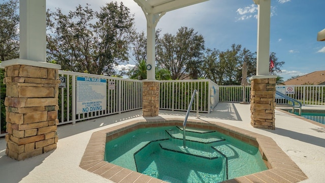 view of swimming pool featuring a hot tub