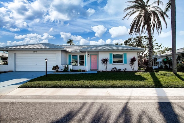 ranch-style house featuring a garage and a front lawn