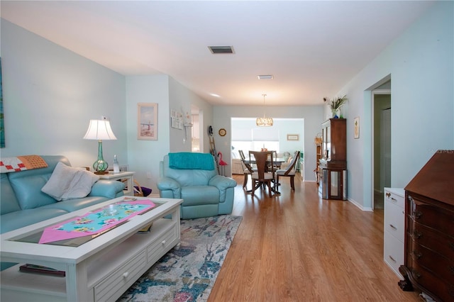 living room featuring a chandelier and light hardwood / wood-style floors