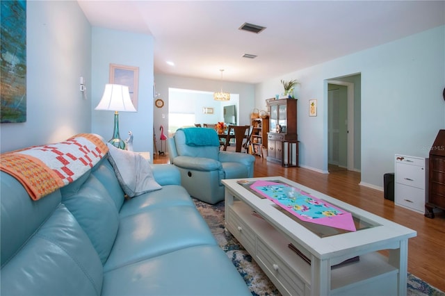 living room with hardwood / wood-style floors and an inviting chandelier