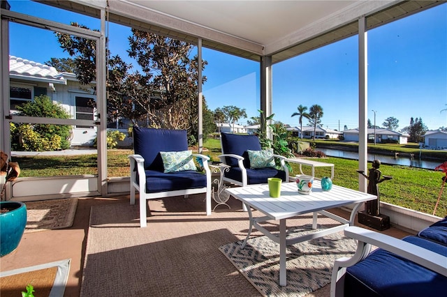 sunroom / solarium featuring a water view