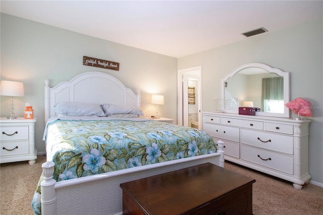 carpeted bedroom featuring ensuite bath