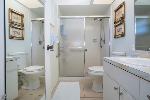 bathroom with tile patterned flooring, vanity, toilet, and a shower with shower door