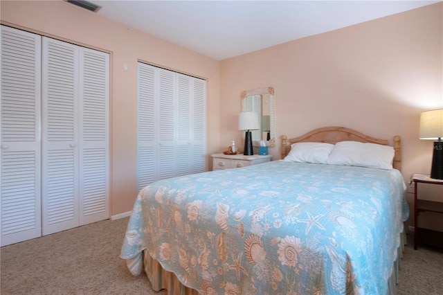 bedroom with carpet floors and two closets