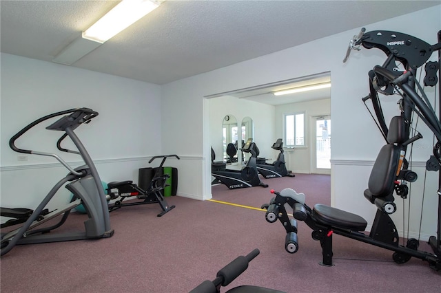 exercise room with a textured ceiling